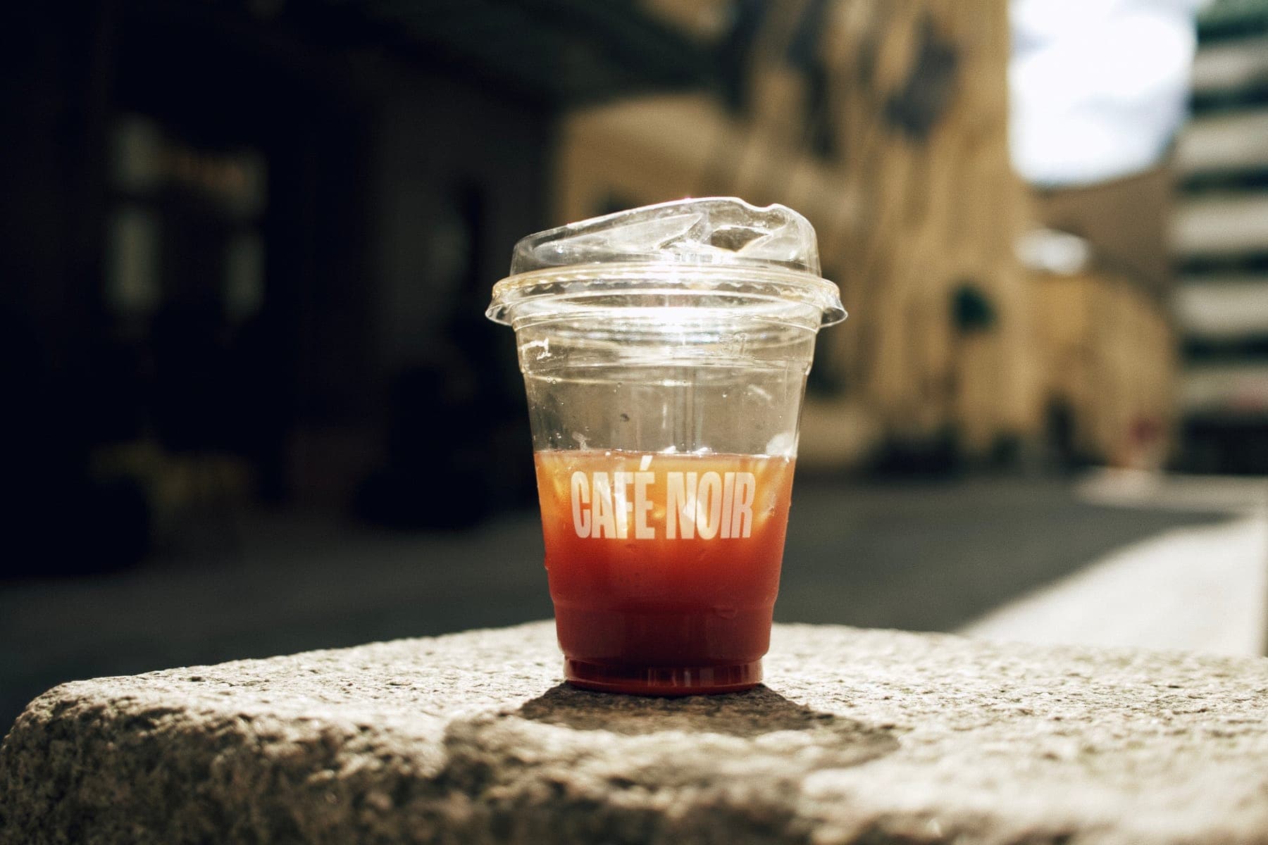 Iced coffee in a Café Noir cup, out in the sun